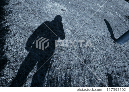 Shadow of a person holding a camera Shadow of a person holding a camera 137593502