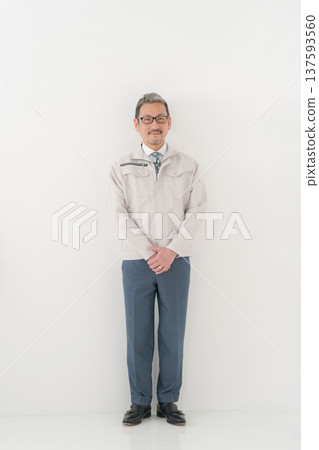 A man in work clothes standing with a smile 137593560