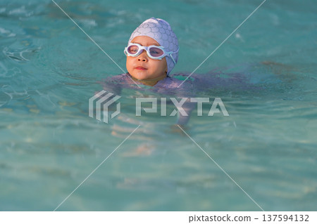 preschool child girl playing and swimming in pool preschool child girl playing and swimming in pool 137594132