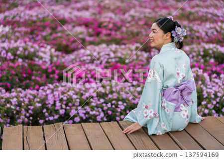 woman in yukata (kimono dress) with flower blooming in garden 137594169