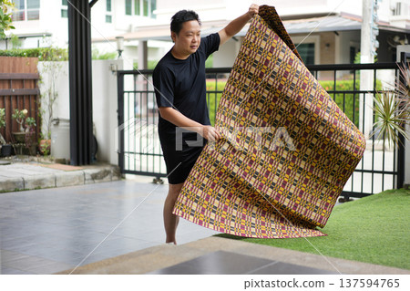 Home Preparation Mindset, He unfolds a mat with care, beginning his day with focus and quiet preparation. Home Preparation Mindset, He unfolds a mat with care, beginning his day with focus and quiet preparation. 137594765