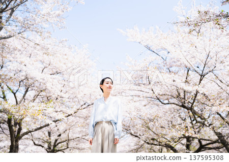 Young woman looking up at cherry blossoms Lifestyle image Young woman looking up at cherry blossoms Lifestyle image 137595308