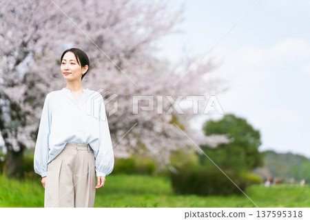 年輕女子在櫻花樹前擺姿勢生活方式圖像 137595318