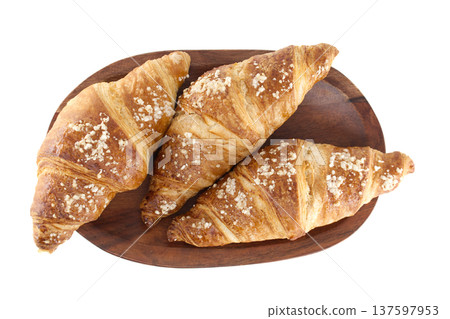 Golden brown croissants sprinkled with sugar on a wooden platter, top view Golden brown croissants sprinkled with sugar on a wooden platter, top view 137597953