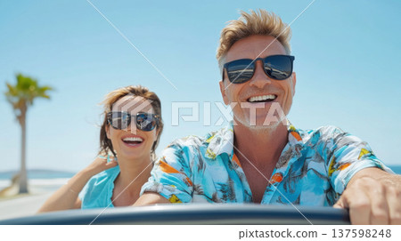 joyful couple enjoying sunny day in convertible car, wearing sunglasses and smiling widely. vibrant atmosphere captures their happiness 137598248
