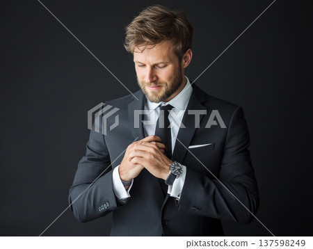 stylish man in tailored suit adjusting his cufflinks, exuding confidence and sophistication against dark background 137598249