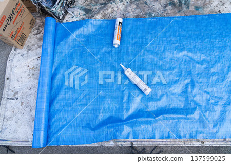 外牆塗裝場地準備:密封膠和施工工具擺放在藍色防水布上。 外牆塗裝場地準備:密封膠和施工工具擺放在藍色防水布上。 137599025