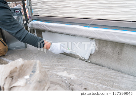 Basic paint maintenance for homes: A worker carefully paints the base coat with a brush 137599045