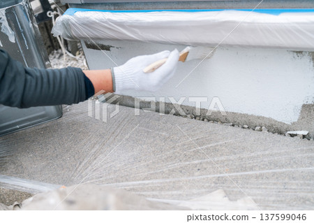 房屋油漆基礎維護：工人用刷子仔細塗抹底漆。 137599046