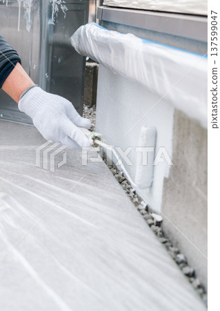 房屋油漆基礎維護：工人用刷子仔細塗抹底漆。 137599047