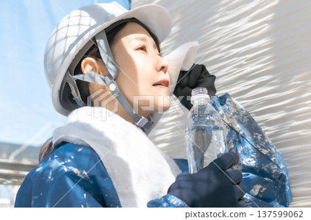 Construction worker wiping sweat with a towel 137599062