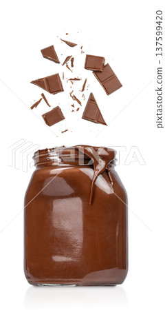 Chocolate spread jar with falling chocolate pieces isolated on white background Chocolate spread jar with falling chocolate pieces isolated on white background 137599420
