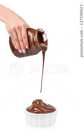 Chocolate spread pouring from jar into bowl isolated on white 137599423