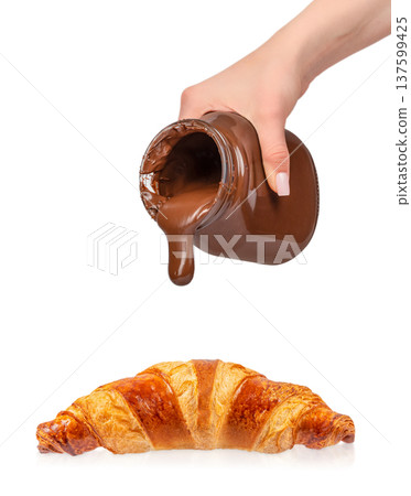 Pouring chocolate spread from jar onto croissant isolated on white background 137599425