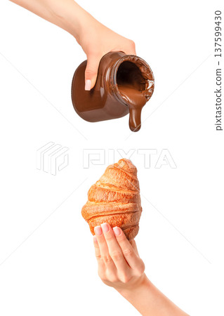 Chocolate spread pouring from jar onto croissant held in hand isolated on white Chocolate spread pouring from jar onto croissant held in hand isolated on white 137599430