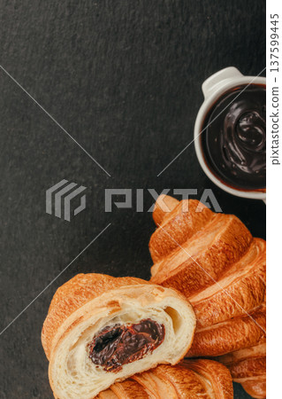 Chocolate croissant with creamy chocolate spread and pastry on dark background with copy space Chocolate croissant with creamy chocolate spread and pastry on dark background with copy space 137599445