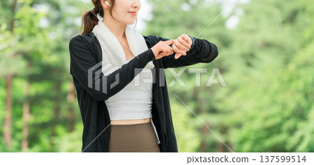 一位女士在運動時操作智慧手錶(醫療保健/音樂/運動) 一位女士在運動時操作智慧手錶(醫療保健/音樂/運動) 137599514