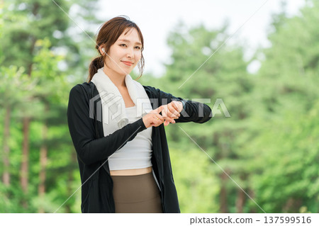 一位女士在運動時操作智慧手錶(醫療保健/音樂/運動) 一位女士在運動時操作智慧手錶(醫療保健/音樂/運動) 137599516