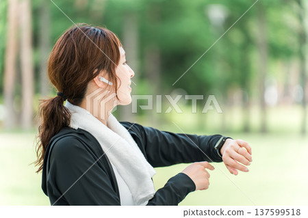 一位女士在運動時操作智慧手錶(醫療保健/音樂/運動) 一位女士在運動時操作智慧手錶(醫療保健/音樂/運動) 137599518