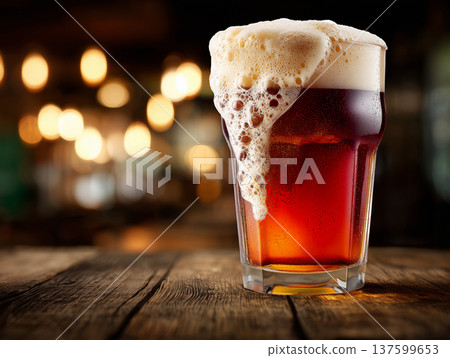 Foamy ruby beer in a pint glass, on a rustic wooden bar background, conveying a concept of refreshment 137599653
