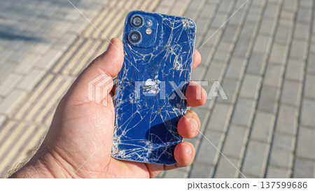 Alanya, Antalya, Turkey - Jan 19 2023, broken Apple iPhone in hand on the background of the sidewalk Alanya, Antalya, Turkey - Jan 19 2023, broken Apple iPhone in hand on the background of the sidewalk 137599686