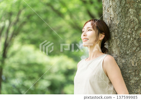 一位女士在森林中進行森林浴（深呼吸、排毒、植物浴） 137599985