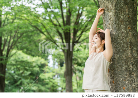 一位女士在森林中進行森林浴（深呼吸、排毒、植物浴） 137599988