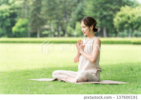 年輕的亞洲女性在公園做瑜珈、瑜珈、皮拉提斯、在森林/公園伸展運動 137600191