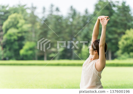 年輕的亞洲女性在公園做瑜珈、瑜珈、皮拉提斯、在森林/公園伸展運動 137600196