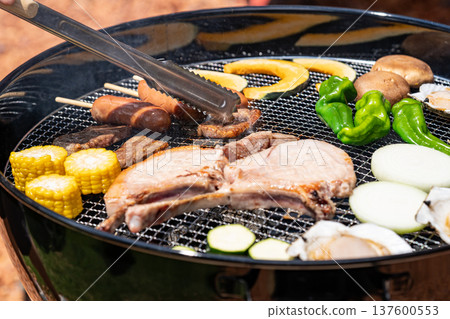 Enjoying a barbecue: Check the doneness with tongs Enjoying a barbecue: Check the doneness with tongs 137600553