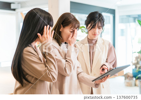 Businesswoman having a meeting while looking at a tablet (review, failure, low rating, word of mouth) Businesswoman having a meeting while looking at a tablet (review, failure, low rating, word of mouth) 137600735