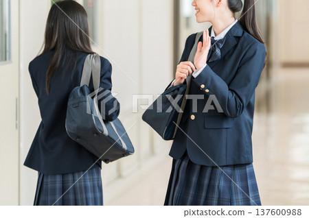 Female students, elementary school students, junior high school students, and high school students in uniform walking down a school corridor 137600988