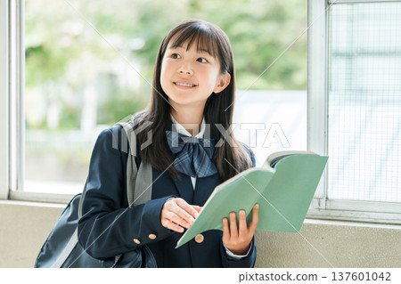 Elementary school, junior high school, and high school girls holding books in school corridors Elementary school, junior high school, and high school girls holding books in school corridors 137601042