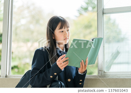 小學、國中和高中女生在學校走廊拿著書 137601043