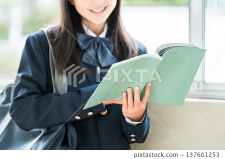 Elementary school, junior high school, and high school girls holding books in school corridors Elementary school, junior high school, and high school girls holding books in school corridors 137601253