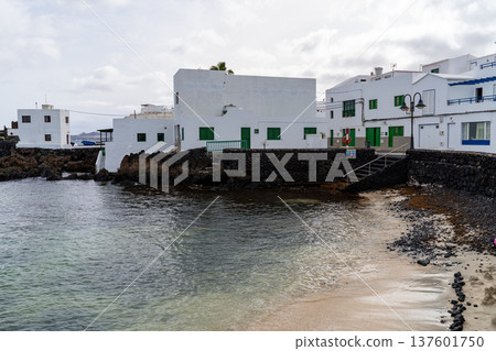 A scenic view in Punta Mujeres, Lanzarote, showcasing white buildings, tranquil waters, and a charming beach. A scenic view in Punta Mujeres, Lanzarote, showcasing white buildings, tranquil waters, and a charming beach. 137601750