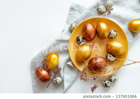 Golden and bronze Easter eggs in a orange plate Golden and bronze Easter eggs in a orange plate 137601866