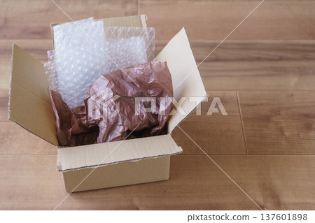 Cardboard and cushioning material (bubble wrap and thin paper) 137601898