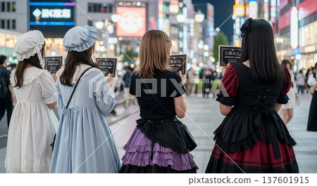 Rear view of a female staff member attracting customers to a concept cafe in a busy area of Tokyo Rear view of a female staff member attracting customers to a concept cafe in a busy area of Tokyo 137601915