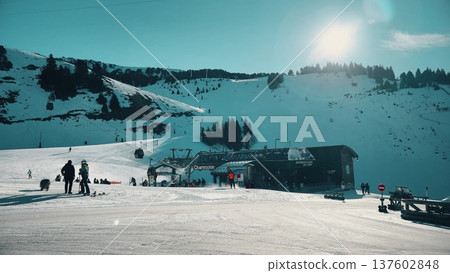 Sunny ski resort slopes, silhouettes of people and gondola station in Chamrousse, French Alps 137602848