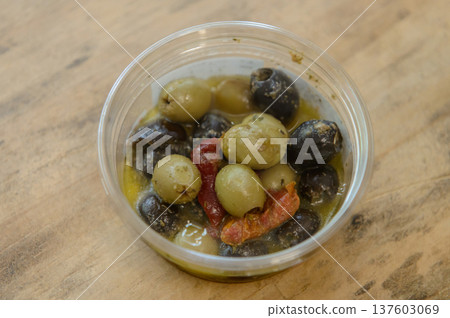 Black and green olives and sun-dried tomatoes in a plastic container Black and green olives and sun-dried tomatoes in a plastic container 137603069