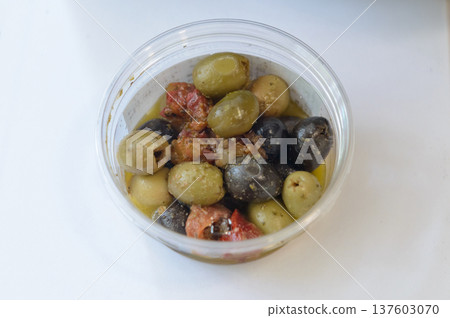 Mixed olives and marinated sun-dried tomatoes on a white background Mixed olives and marinated sun-dried tomatoes on a white background 137603070