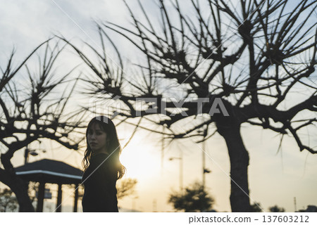 Woman enjoying a walk at sunset Woman enjoying a walk at sunset 137603212
