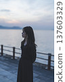Woman looking at the sea at sunset 137603329