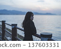 Woman looking at the sea at sunset 137603331