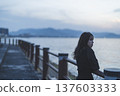Woman looking at the sea at sunset 137603333