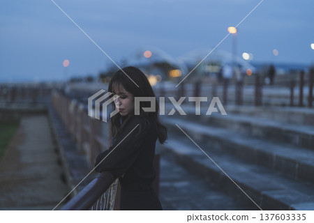 Woman looking at the sea at sunset Woman looking at the sea at sunset 137603335