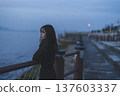 Woman looking at the sea at sunset 137603337