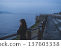 Woman looking at the sea at sunset 137603338