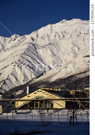 A view of Hakuba Station and the Ushiro-Tateyama mountain range bathed in the morning sun from near Tenjinzaka in Hakuba Village in the dead of winter A view of Hakuba Station and the Ushiro-Tateyama mountain range bathed in the morning sun from near Tenjinzaka in Hakuba Village in the dead of winter 137604529